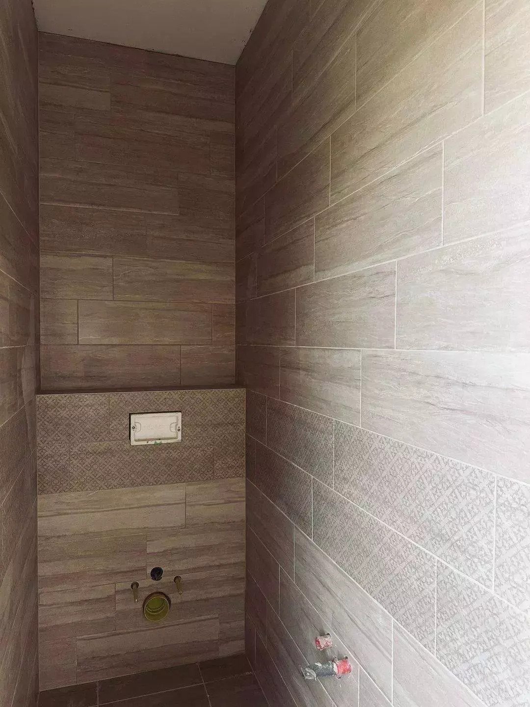 Exklusives Gäste-WC mit hochwertiger Holzoptik-Keramik und dekorativem Mosaikmuster