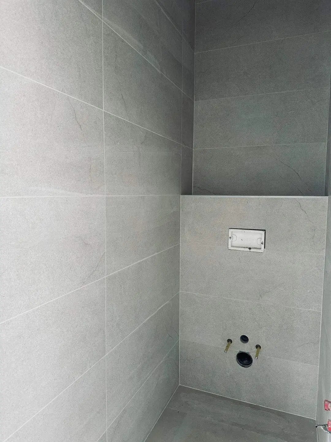 Exklusive Wohlfühloase: Hochwertig geflieste Dusche mit moderner Wandgestaltung und intelligenter Installationstechnik