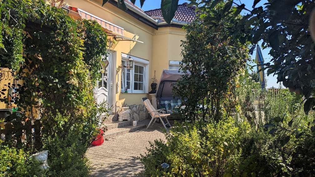 Idyllische Terrasse mit natürlicher Steinmauer und üppiger Bepflanzung - Ihr privates Gartenparadies wartet!
