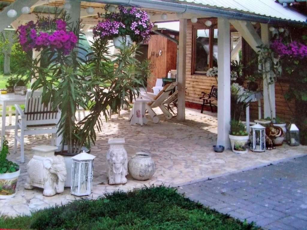 Mediterrane Wohlfühl-Terrasse: Naturstein-Ambiente mit überdachter Entspannungszone und charmantem Gartenzugang