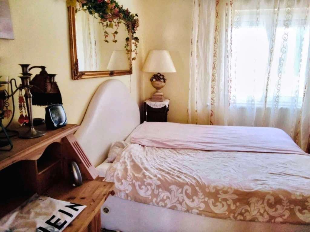Gemütliches Schlafzimmer mit großzügiger Kopfbettkonstruktion und stimmungsvoller Lichtführung - Ihr persönliches Ruheoase mit charmantem Landhausflair!