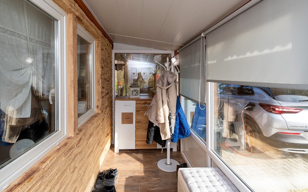 Sonnendurchflutete Loggia mit großflächigen Verglasungen und hochwertiger Holzausstattung Sonnendurchflutete Loggia mit großflächigen Verglasungen und hochwertiger Holzausstattung
