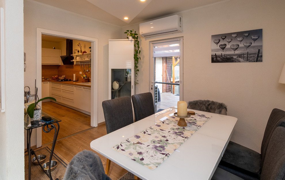 Offenes Wohn- und Essbereich mit direktem Zugang zur Terrasse und moderner Klimaanlage Offenes Wohn- und Essbereich mit direktem Zugang zur Terrasse und moderner Klimaanlage