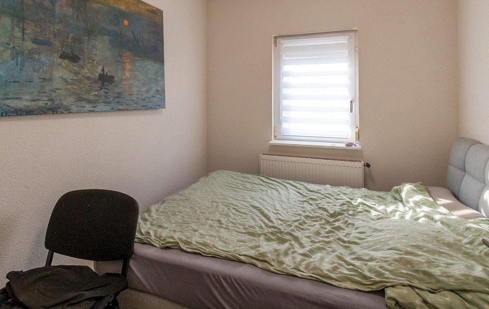 Helles Schlafzimmer mit Fensterfront und integrierter Heizanlage